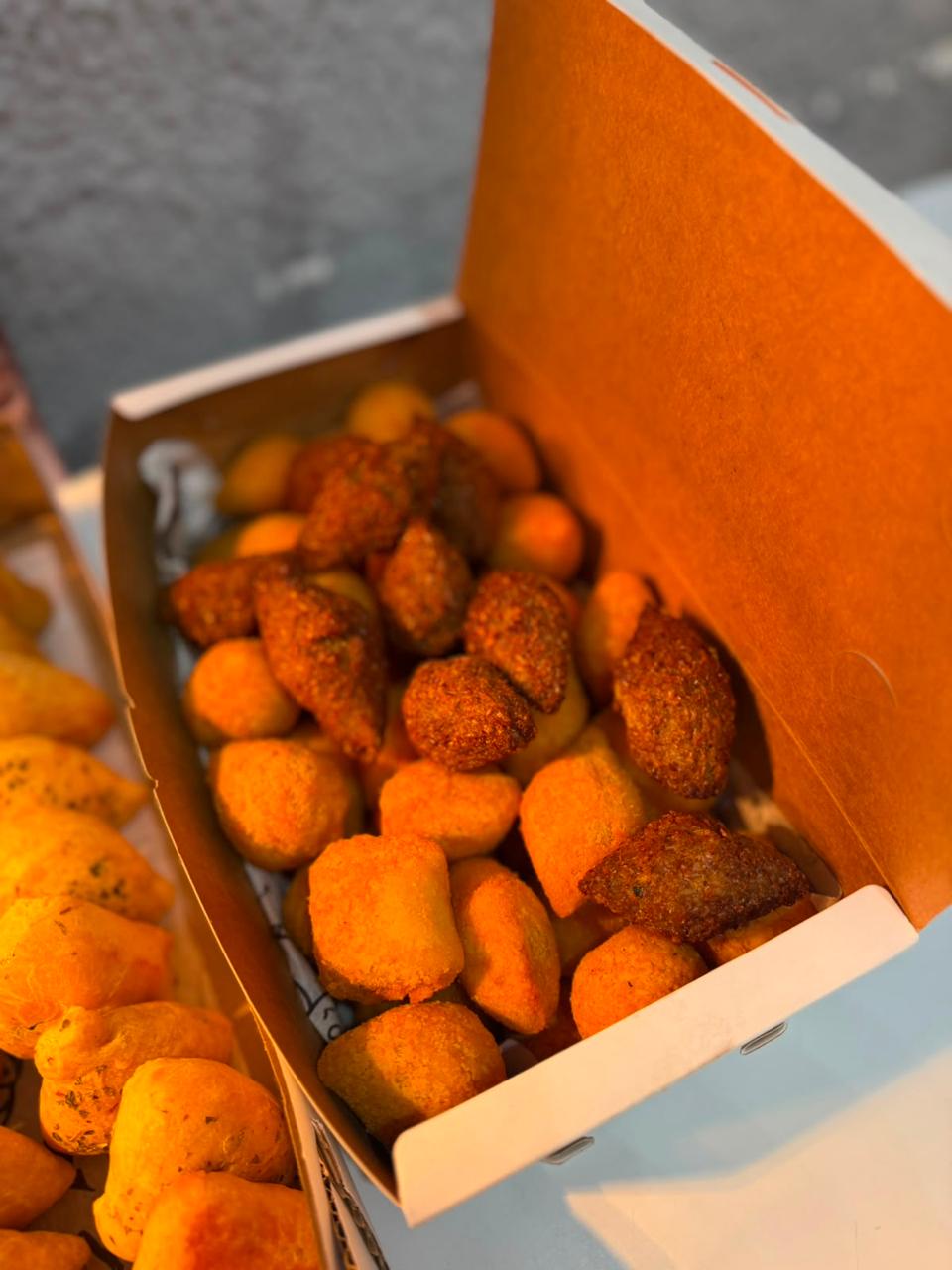 Caixa aberta com salgados variados para festa